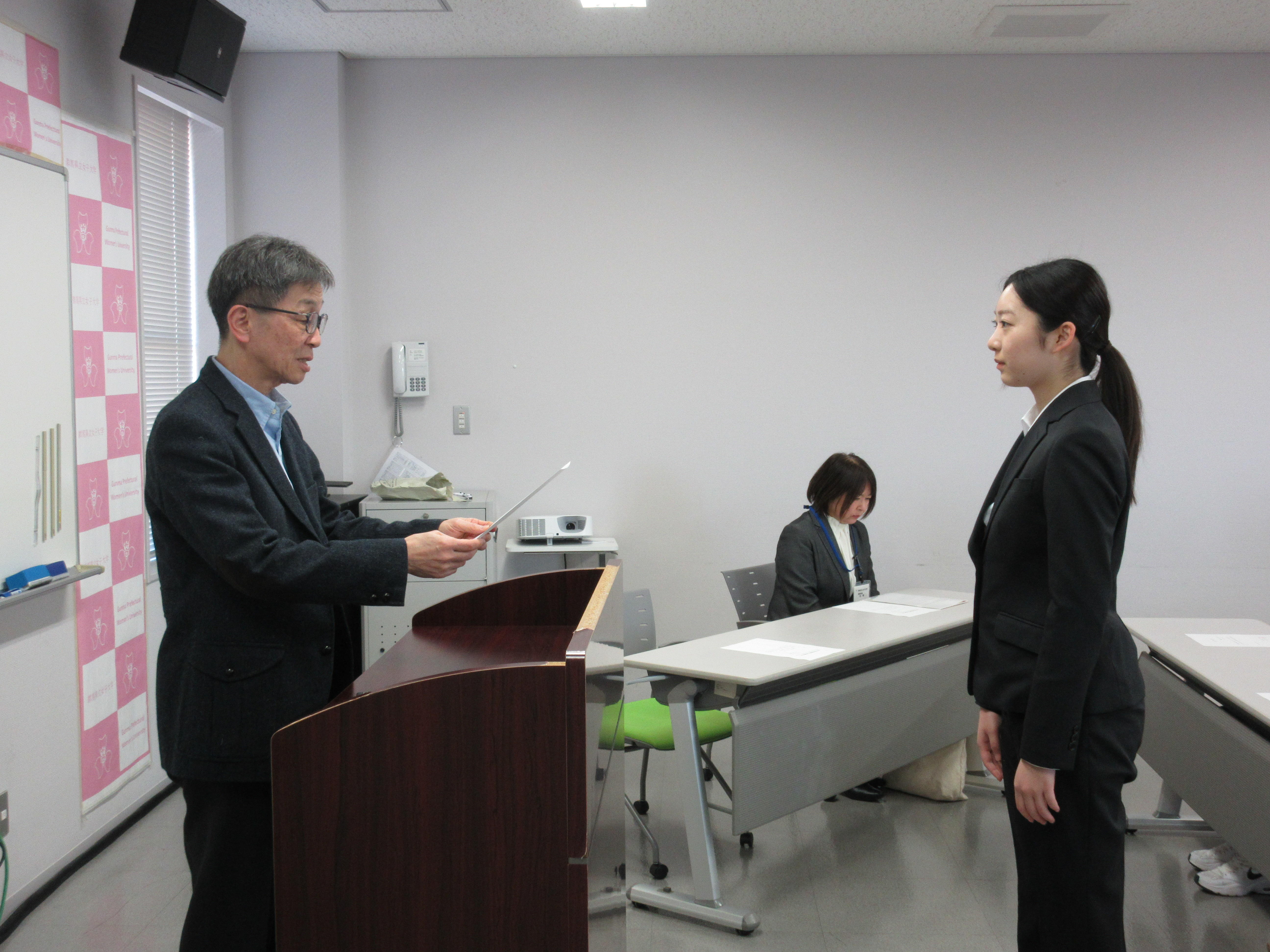 学生に群馬県親善学生大使委嘱状を渡す塩澤寛樹学長