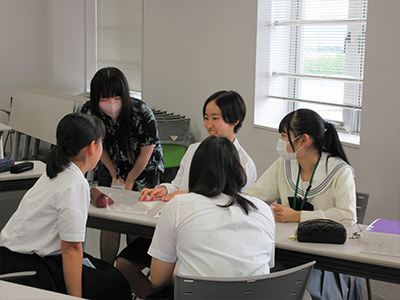 県立女子大学学生チューターのサポートを受けながら英語の活動をする塾生の様子