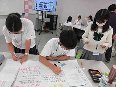 振り返りの内容をまとめたポスターを作成する様子
