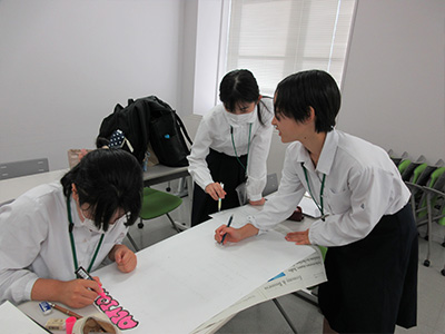 振り返りの内容をまとめたポスターを作成する様子