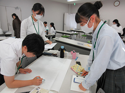 振り返りの内容をまとめたポスターを作成する様子