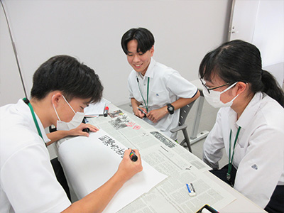振り返りの内容をまとめたポスターを作成する様子