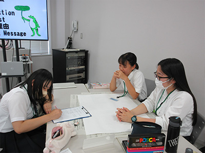 振り返りの内容をまとめたポスターを作成する様子